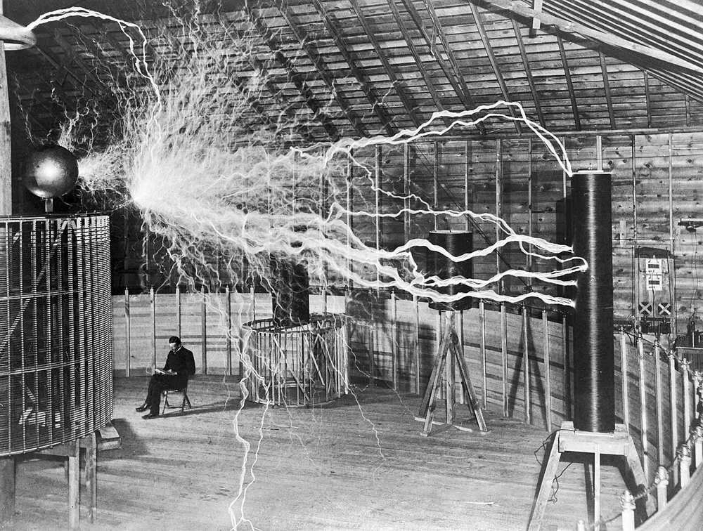 Nikola Tesla in his Colorado Springs laboratory in 1899, with giant electrical discharges from his magnifying transmitter